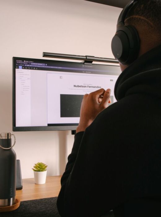 a person wearing headphones and looking at a computer screen